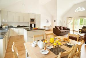 een keuken en een woonkamer met een tafel en stoelen bij Ramson Lodge in Chappel