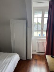 una camera con un letto bianco e una finestra di Chez Marco a La Gouesnière