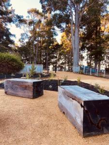 dos cajas de madera sentadas en el suelo en un parque en Adventure Bay Holiday Home en Adventure Bay