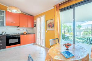 a kitchen with orange cabinets and a table in front of a window at Il piccolo gelso in Marzamemi