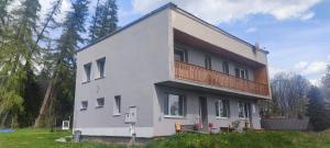 uma casa branca com uma varanda em cima em Ružová Vila em Banská Štiavnica