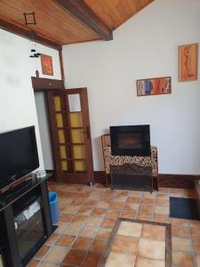 sala de estar con TV y chimenea en Le sud de St Just d'Avray, en Saint-Just-dʼAvray