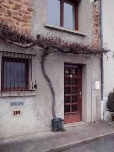 un edificio con un árbol delante de una puerta en Le sud de St Just d'Avray, en Saint-Just-dʼAvray