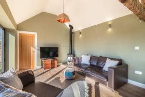 a living room with a couch and a tv at Green End Farm Cottages - The Sheep Shed in Whitby