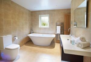 a bathroom with a tub and a toilet and a sink at Campion Lodge in Chappel