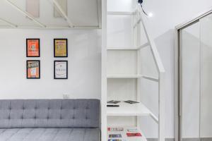a living room with a staircase and a gray couch at San Donato - Grazioso Moderno Monolocale - 600 m Metro Principi d'Acaja in Turin