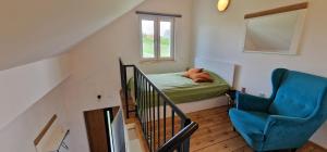 Habitación pequeña con cama y silla azul en Zimna Apartments, en Kwidzyn