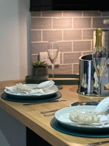 a table with two plates and a glass of wine at Barn Owl Lodge in Lowestoft