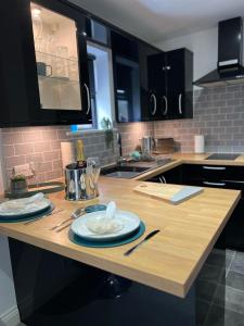 a kitchen with a wooden table with plates on it at Barn Owl Lodge in Lowestoft