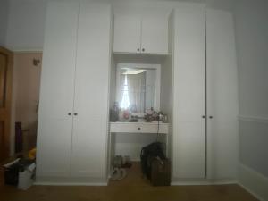 ein weißes Zimmer mit weißen Schränken und einem Spiegel in der Unterkunft Mid City Charm - 1-Bed Apartment in London in London