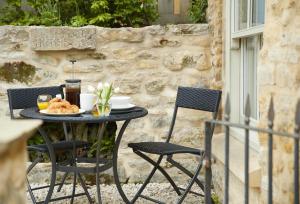 a table with a plate of food on a patio at Mason's Cottage in Ampleforth