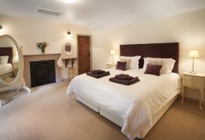 a bedroom with a large white bed and a fireplace at Courtyard House in Kelso