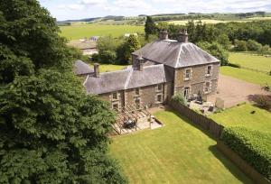 an aerial view of a large stone house with a yard at Courtyard House in Kelso