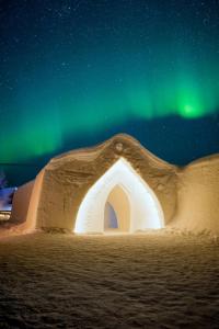 um iglu sob as estrelas com a aurora boreal em Arctic SnowHotel & Glass Igloos em Sinettä