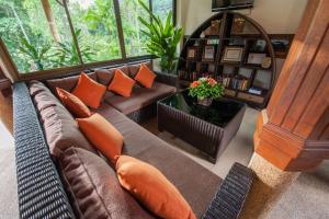 a living room with a brown couch and orange pillows at Pinnacle Samui Resort in Mae Nam