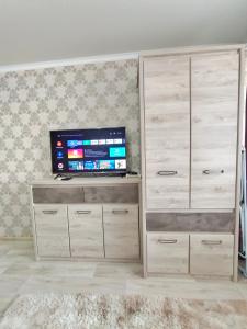 un centro de entretenimiento con TV de pantalla plana en una habitación en Люксовые апартаменты в Центре г.Семей, en Semey