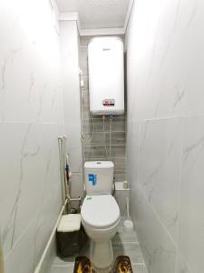 - une petite salle de bains avec toilettes et un réservoir dans l'établissement Люксовые апартаменты в Центре г.Семей, à Semey
