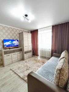 1 dormitorio con 1 cama y TV de pantalla plana en Люксовые апартаменты в Центре г.Семей, en Semey