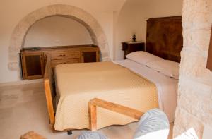um quarto com uma cama num quarto com um arco em Trullo Cinquenoci em Locorotondo