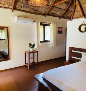 a bedroom with a bed and a mirror at Mangal Beach Lodge in Vilanculos