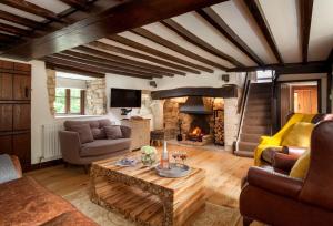 a living room with a table and a fireplace at Smithycroft in Combe Saint Nicholas
