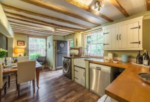 a kitchen with white cabinets and a table and a dining room at Pillar Box House in Kimberley