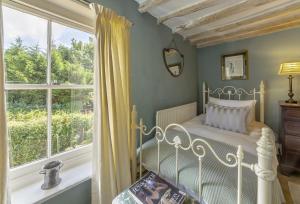 a bedroom with a white bed and a window at Pillar Box House in Kimberley