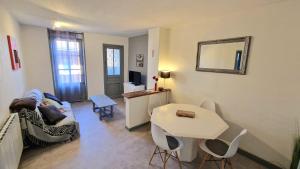 a living room with a couch and a table at Appart hôtel Roanne hyper centre ville in Roanne