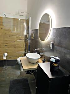 ein Badezimmer mit einem weißen Waschbecken und einem Spiegel in der Unterkunft La casa di Eva in Avola