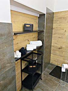 ein Badezimmer mit Holzwänden und Handtüchern auf einem Regal in der Unterkunft La casa di Eva in Avola