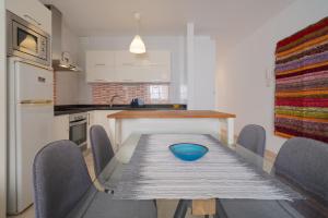 阿雷西費的住宿－Sabbia Suites Casa Nina，厨房配有桌椅和蓝色碗