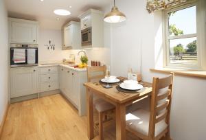 eine Küche mit einem Holztisch sowie einem Tisch und Stühlen in der Unterkunft Pear Tree Cottage Shropshire in Orleton