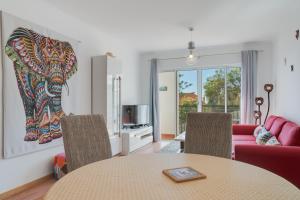 una sala de estar con una mesa y un sofá en Alta do Garajau II, en Caniço