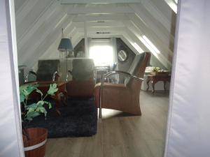 sala de estar con sillas, mesa y ventana en B&B De Boeren Zwaluw, en Slochteren