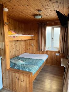 a small room with a bed in a boat at Cove Shepherds Hut in Penally