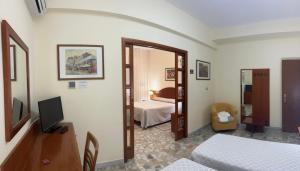 a room with a bedroom with a bed and a television at Il Nocchiero City Hotel in Soverato Marina