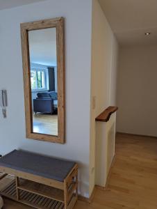 a mirror on a wall with a bench in a room at Ferienwohnung Apimundi in Lauterach