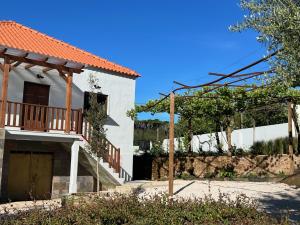 a house with a porch and a balcony at Casa Bizarra in Castanheira de Pêra