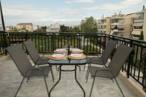 stół z 4 krzesłami na balkonie w obiekcie Medea's Luxury Apartment w mieście Perea