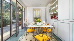 a kitchen and dining room with a table and chairs at VILLA GAIUS 8&2, Emma Villas in Rosignano Marittimo
