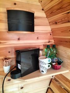un microondas sentado en un estante en una casa pequeña en Campingfässer Weener en Weener