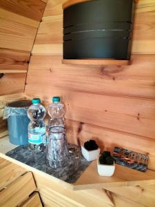 een plank met twee glazen flessen en enkele planten bij Campingfässer Weener in Weener