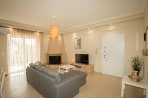 salon z kanapą i telewizorem w obiekcie Medea's Luxury Apartment w mieście Perea