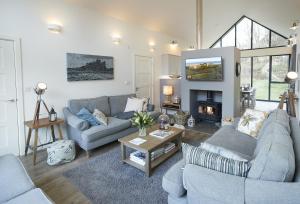 uma sala de estar com dois sofás e uma lareira em Mallow Lodge 6 em Bamburgh