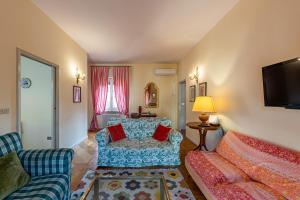 un soggiorno con un divano e una TV di Residenza Corsocangrande25 a Lazise