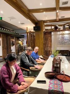 eine Gruppe von Menschen, die an einem Tisch in einem Restaurant sitzen in der Unterkunft SecGarden Boutique Hotel in Zhangjiajie