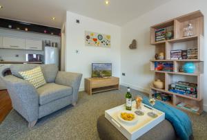 - un salon avec un canapé et une table dans l'établissement Beau View Cottage, à Bekesbourne