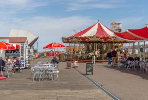 a pier with a carousel and tables and chairs at Beau View Cottage in Bekesbourne