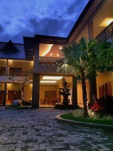 una casa con una palma di fronte di Syailendra Hotel Syariah a Jepara