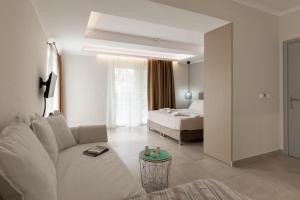 a living room with a couch and a bed at Elite City Apartments & Maisonettes in Lefkada